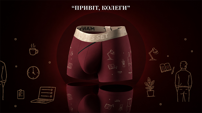 Чоловічі боксерки насиченого бордового кольору з бежево-золотистою резинкою Man's Set. На тканині виробу зображені тонкі золотисті контури настільної лампи, розгорнутих книг, кімнатної квітки у горщику та силуету чоловіка. Композиція представлена на темно-червоному градієнтному фоні з великим заголовком "ПРИВІТ, КОЛЕГИ" та розсіяними навколо іконками ноутбука, годинника та фікусів.